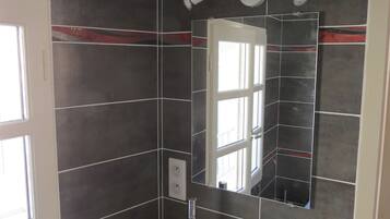 Een douche, handdoeken, toiletpapier