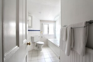 Kylpyhuone, jossa on wc, pesuallas ja kylpyamme.