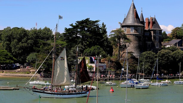 A historic castle with a tower, surrounded by a body of water with several boats. - New in Pornic T2 terrace SO view golf parking all on foot (Pornic)
