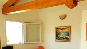 A bedroom with a bed, wooden furniture, a painting, and a window. - Studio 25 M2, air-conditioned 350mt from the beach. (Hyères)