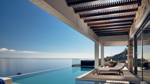 A modern infinity pool with a clear view of the sea, wooden deck, and outdoor seating area. - Alkyonides Villas (Zakynthos)