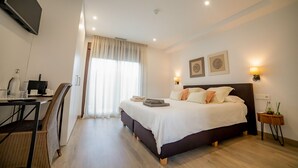 A hotel room with a bed, bedside table, lamp, and a desk with a chair. - Casa Rural Canelobre (Busot)