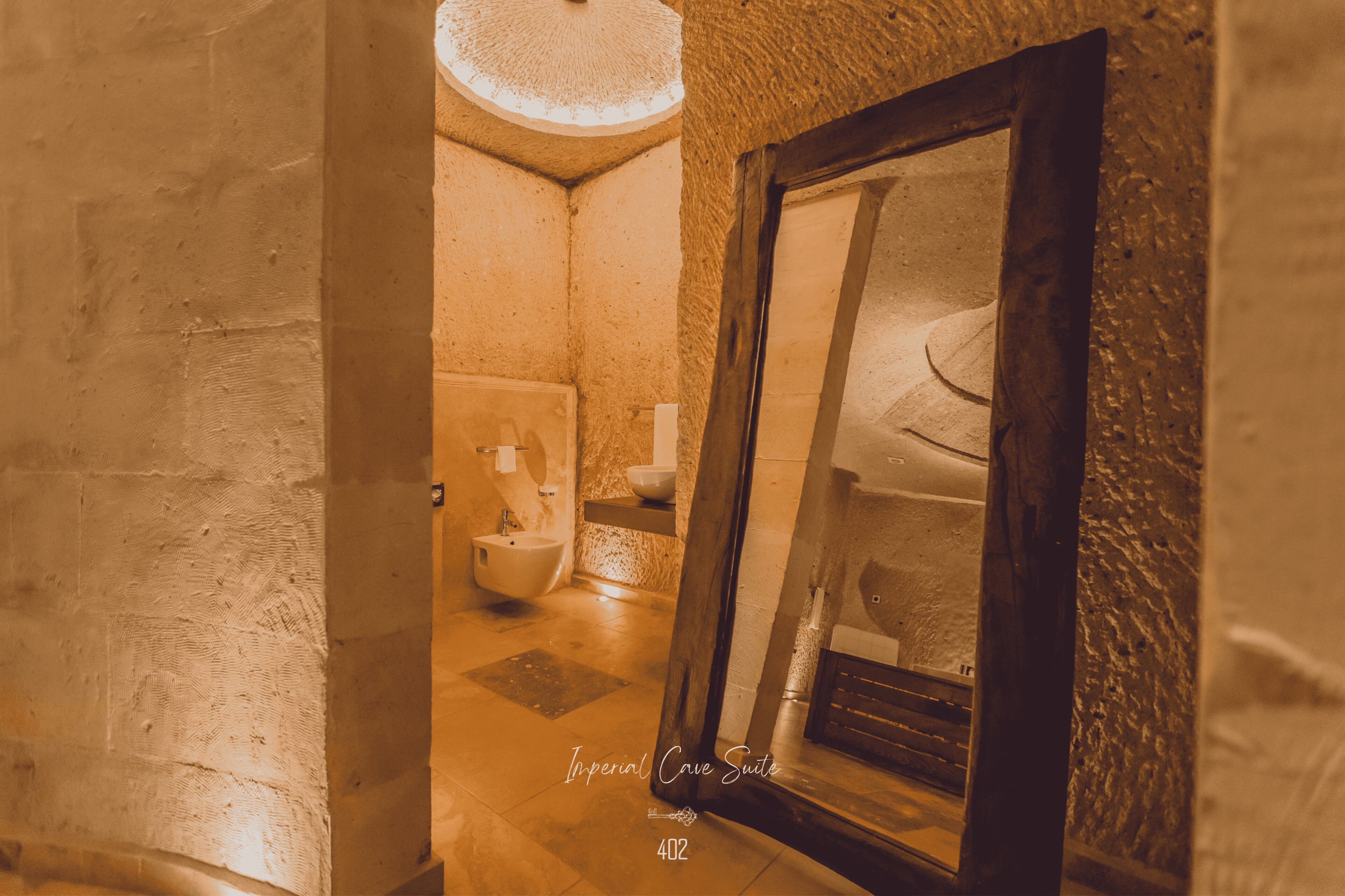 A bathroom with a bidet, a sink, and a mirror.
