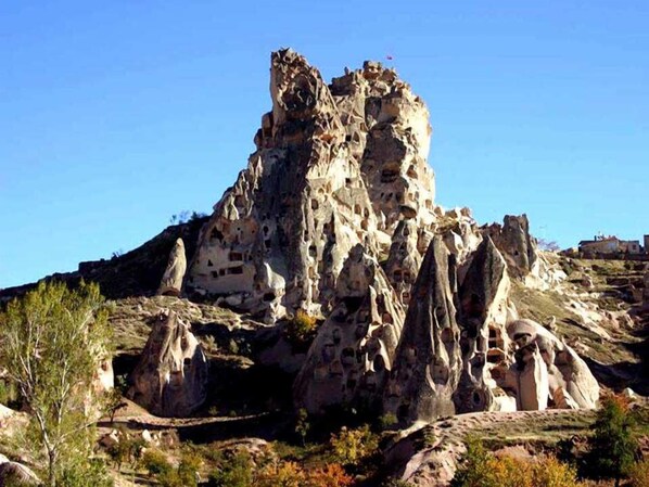 Una montaña escarpada y rocosa con un pico destacado y múltiples cuevas.