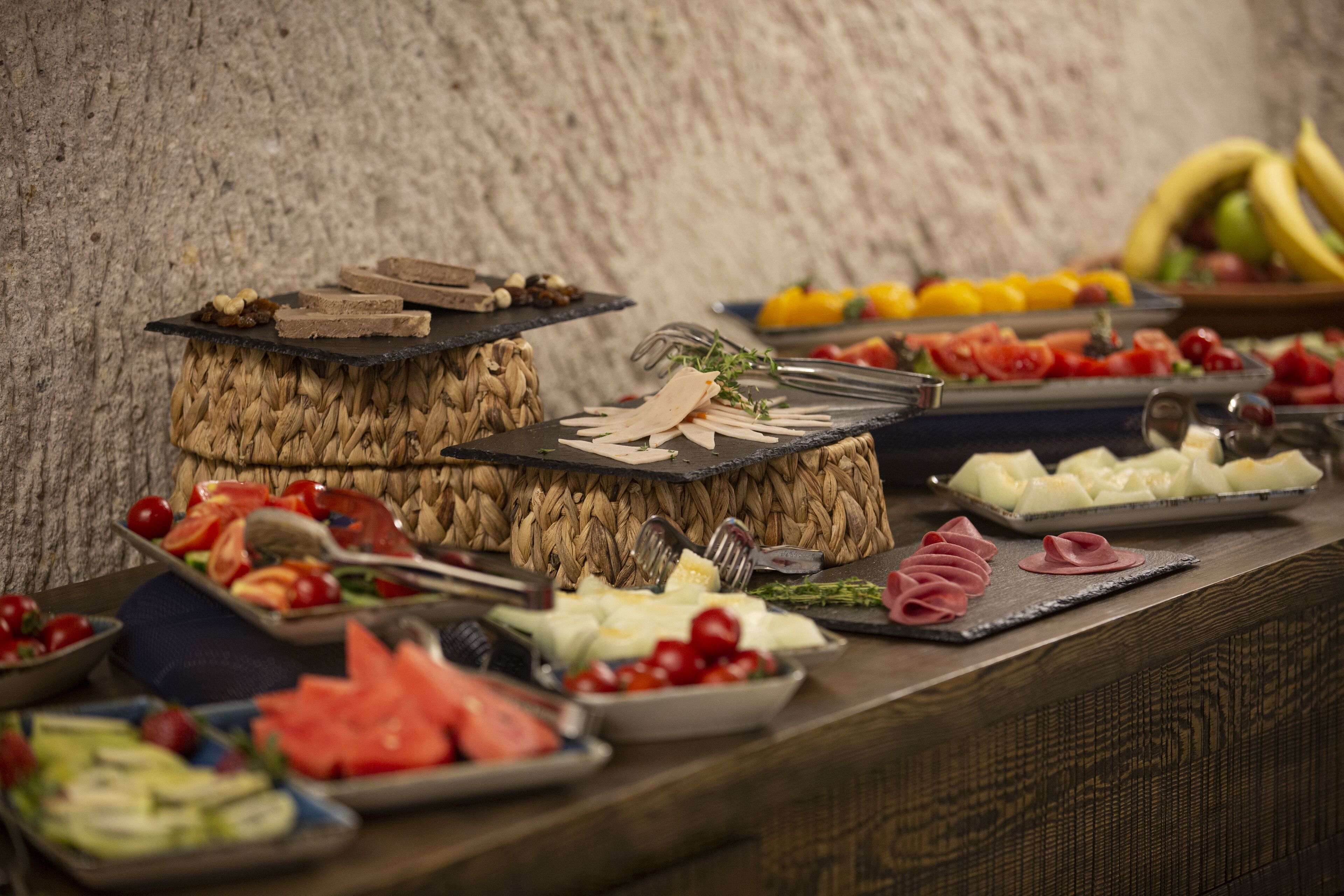 A buffet with various food items including fruits, vegetables, and meats.