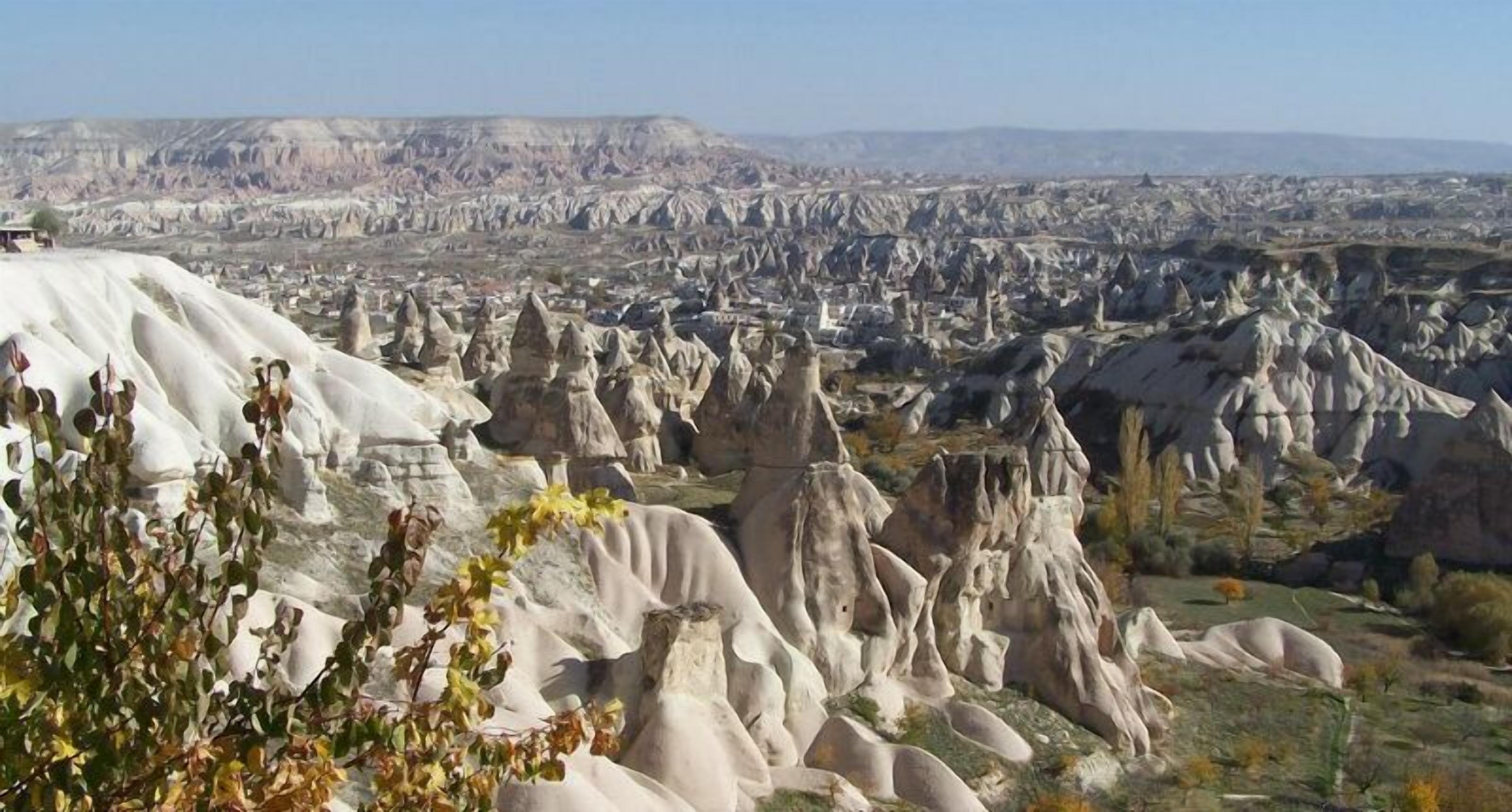 A landscape with distinctive white rock formations and a distant town.