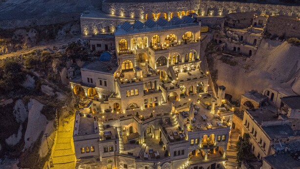 Un edificio histórico de varios niveles, con ventanas arqueadas y un patio interior.