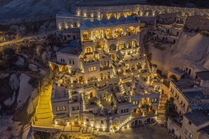 A historic building with multiple levels, featuring arched windows and a courtyard. - Nino Cave Suites (Ürgüp)