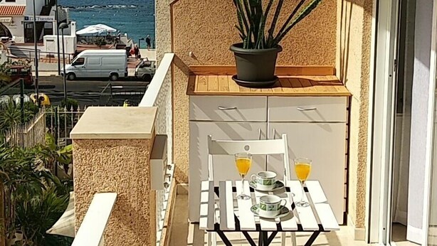 A balcony with a table set for two, a potted plant, and a view of the sea. - Las Vistas Beach 2 minutes to the Beach (Arona)