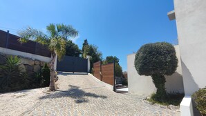Un vialetto acciottolato che conduce a un cancello con un muro in pietra e una recinzione in legno.