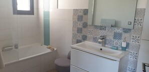 Bañera, secador de pelo, toallas y papel higiénico