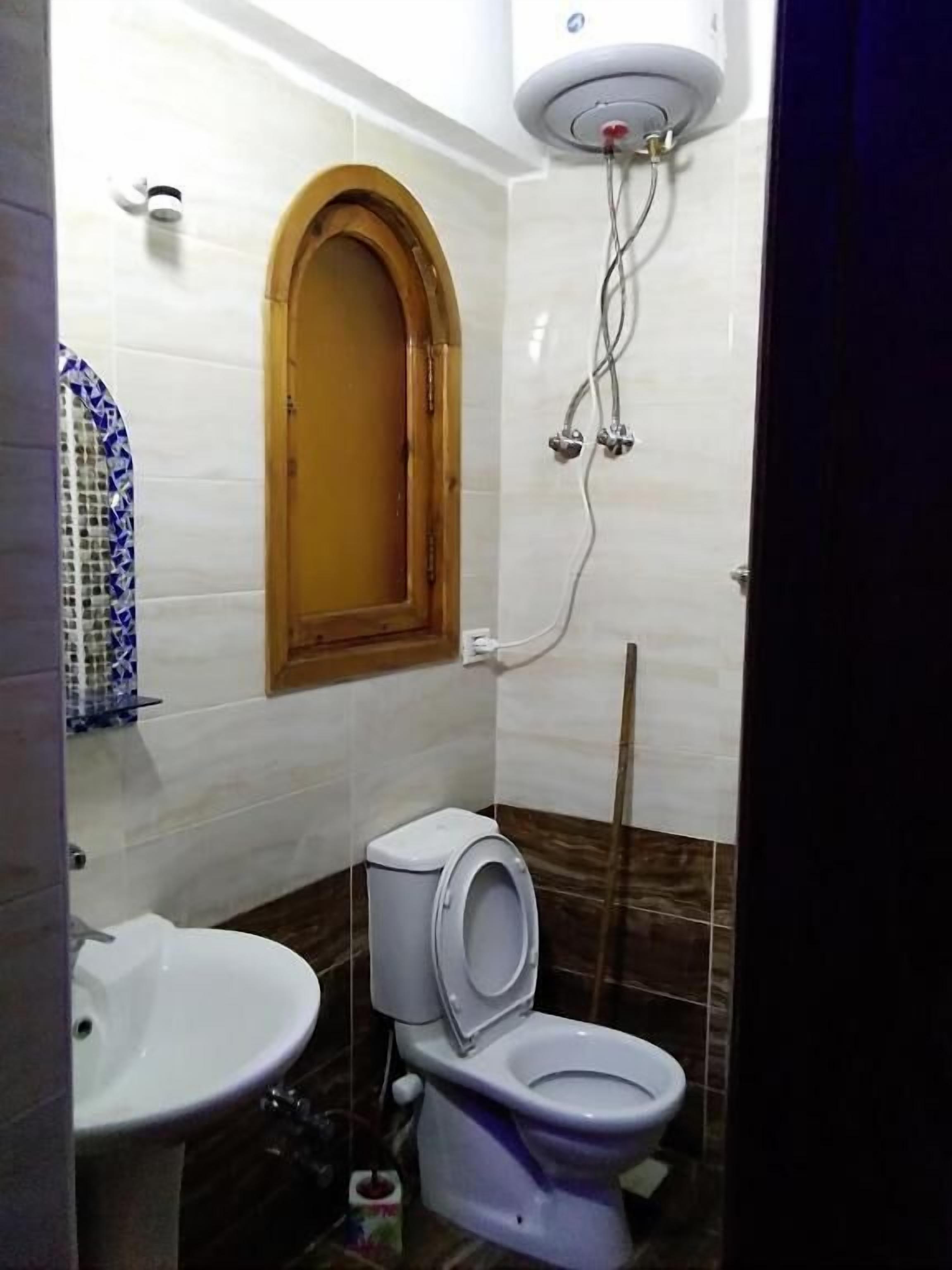 A bathroom with a toilet, sink, and shower.