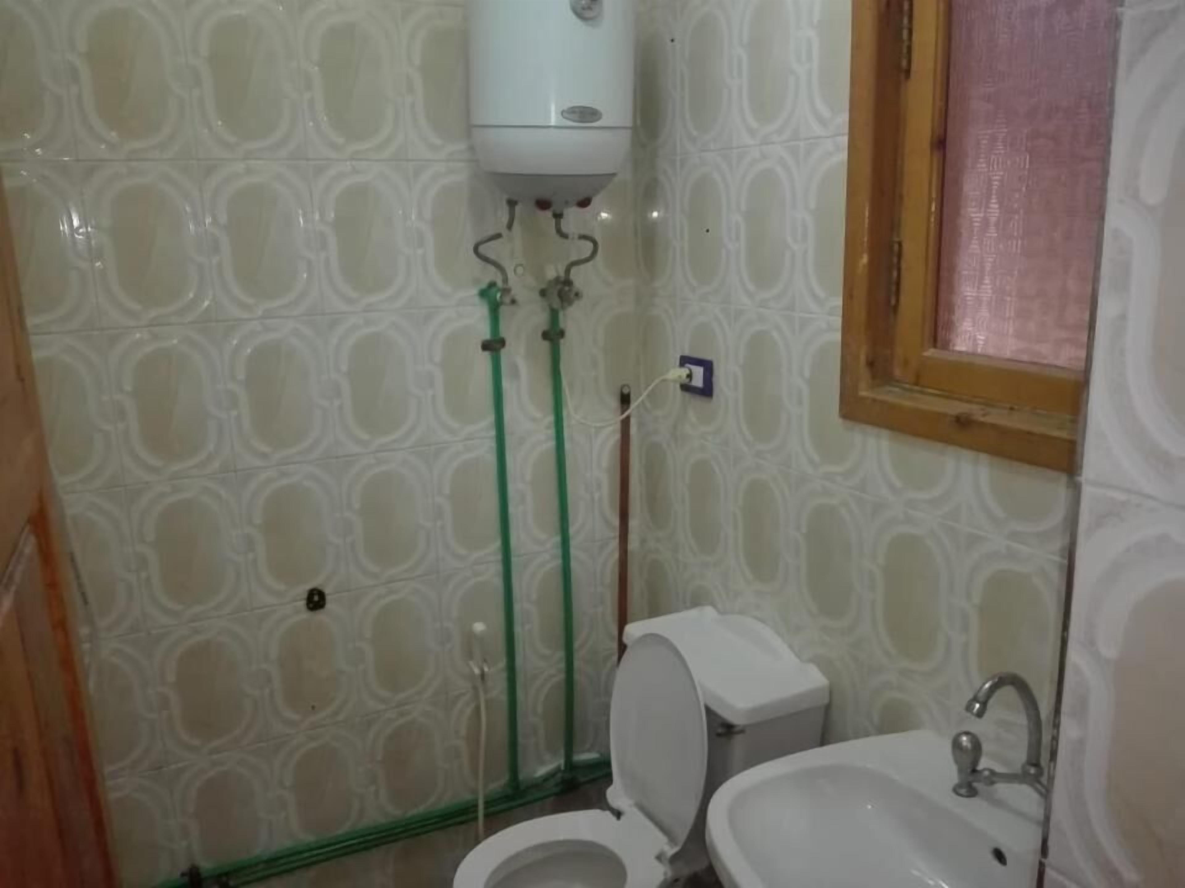 A bathroom with a toilet, bidet, and sink.