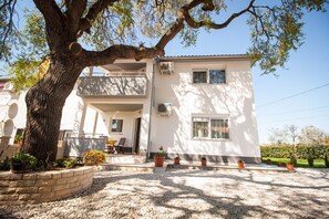 Stunning two-story residence with a spacious balcony and a charming garden setting.