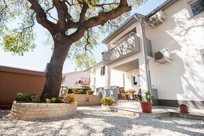 Enjoy a peaceful retreat with a spacious outdoor area, balcony, and patio, surrounded by lush greenery and comfortable seating.