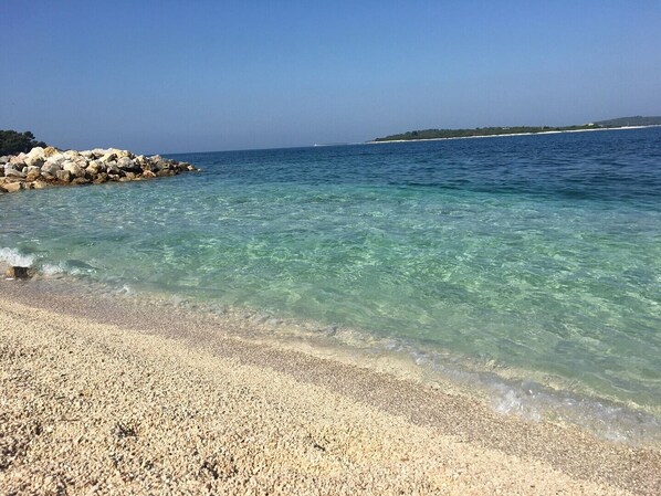 Enjoy a serene beach experience with clear waters and a natural shoreline.