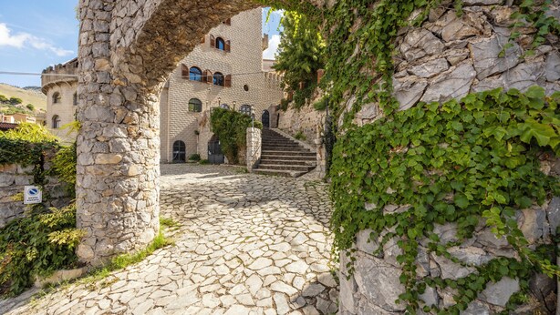 A stone pathway leading to a building with a stone archway. - Hotel Castello di Giuliano (Montelepre)