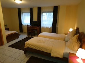 A hotel room with two beds, a desk, and a chair. - Euro-Hotel (Saarbrücken)