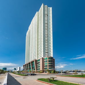 Un hotel alto y moderno con una sección inferior curva y una sección superior recta.