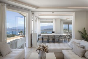 Un'ampia zona giorno con balcone, angolo ristoro e vista sulle montagne.