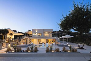 Una moderna casa a due piani con piscina, area relax all'aperto e giardino curato.
