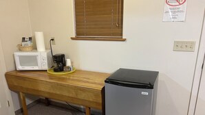 Eine Küchenzeile mit Mikrowelle, Kaffeemaschine und Kühlschrank.