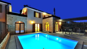 A modern house with a swimming pool, stone walls, and a patio area with outdoor furniture. - Charming 3-BR villa with private pool close to beaches (Novigrad)