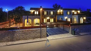 A two-story house with a stone facade, multiple windows, and a well-lit entrance. - Charming 3-BR villa with private pool close to beaches (Novigrad)