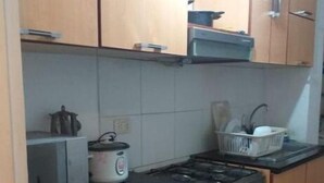 Cuina compacta amb armaris de fusta, fogó a gas, forn integrat i torradora.