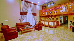 A lobby with leather sofas, a reception desk, and a chandelier. - Royal Ruby Hotel (Mandalay)