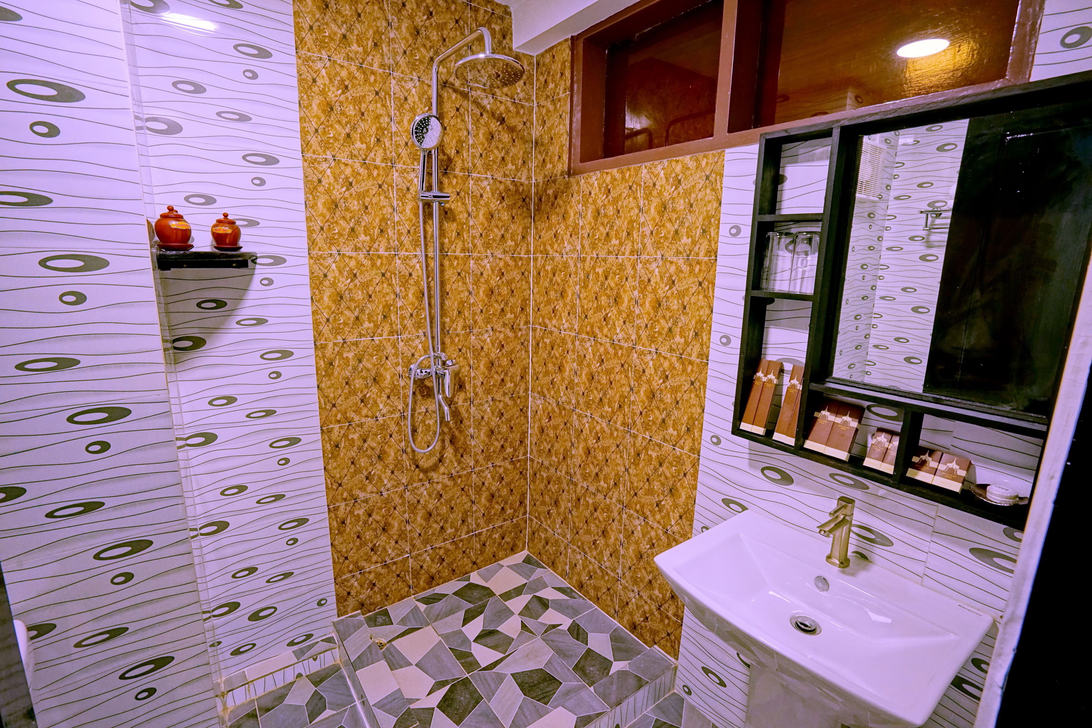 A bathroom with a shower, sink, and tiled walls.