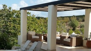 An outdoor patio area with a pergola, stone flooring, and outdoor furniture. - Villa Koumneni - Sea and mountain peace and tranquility (Paphos)