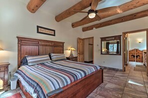 Una camera da letto con un letto in legno, una ventola a soffitto, un comodino, una lampada da comodino e un'armadio in legno.