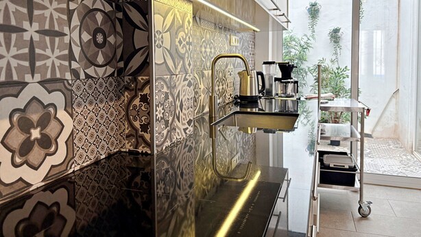 A modern kitchen with patterned tiles, a stainless steel sink, and a coffee machine. - AP290 - Casa Olivia (Nerja)