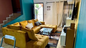 Ein Wohnzimmer mit einer Sofagarnitur, einem Couchtisch und einem Fernseher.