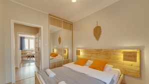 A modern bedroom with a large bed, wooden headboard, and a mirror. - Dream Loft Krosna (Gdansk)