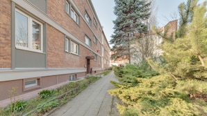 A pathway flanked by a brick building with windows and a small entrance. - Dream Loft Krosna (Gdansk)
