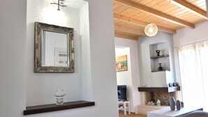 Un salon avec un plafond en bois, une cheminée, un canapé et un téléviseur.