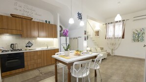A modern kitchen with wooden cabinets, a dining table with white chairs, and a kitchen island.