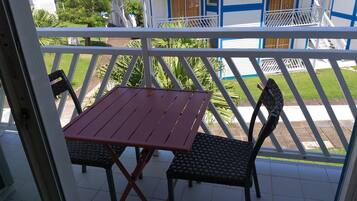 A balcony with a table and two chairs.