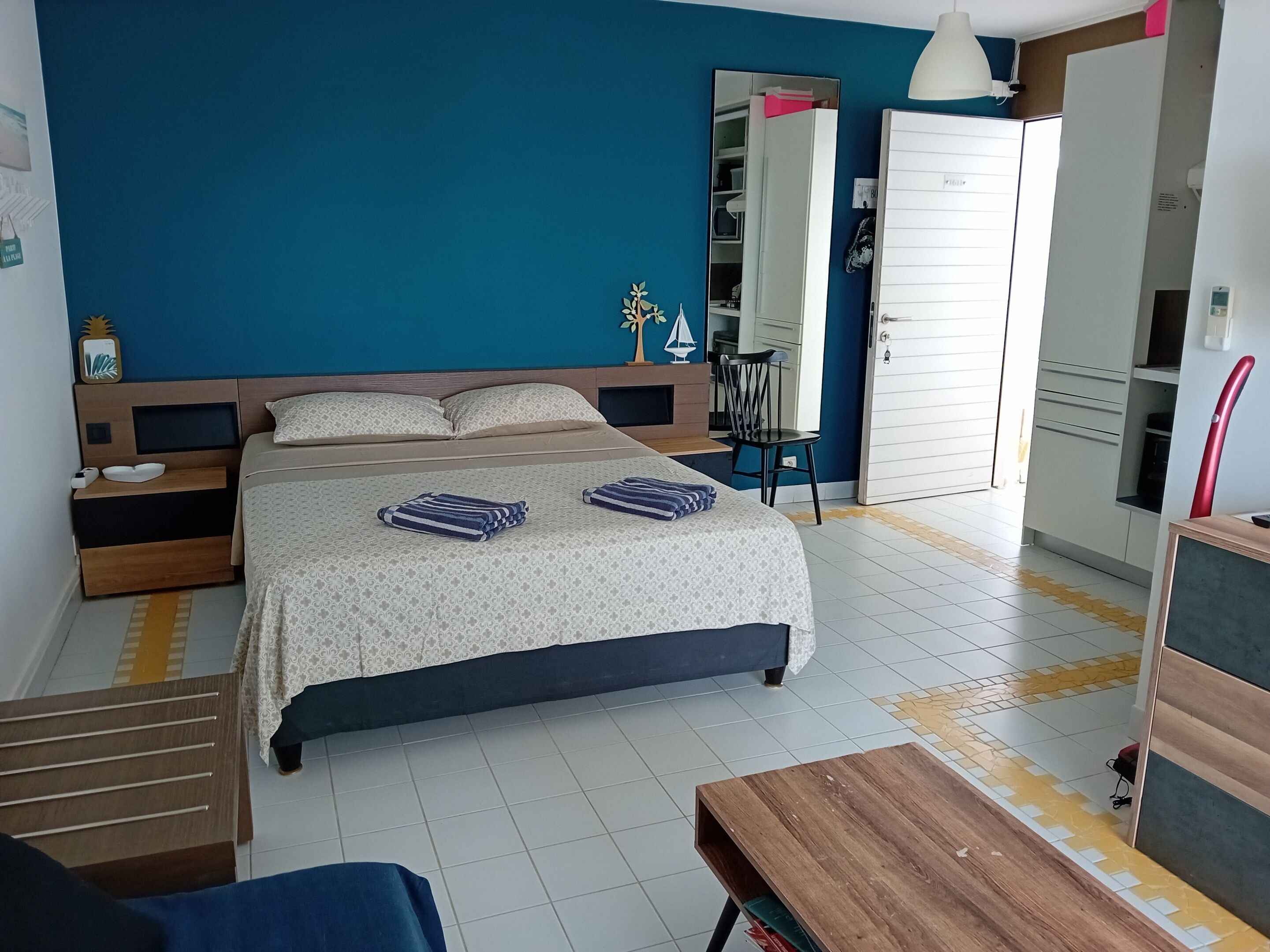 A bedroom with a bed, bedside tables, a chair, a desk, and a wardrobe.