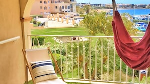 A balcony with a chair, a hanging red fabric, a bottle, and a decorative lantern. - Large terrace, 50m from beach with sea view + private pool (Six-Fours-les-Plages)