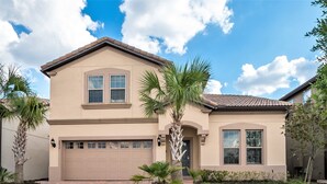 A two-story house with a beige facade, a brown garage door, and a well-maintained lawn with palm trees. - Perfect Retreat 8BR/6BA Pool Home in Windsor at Westside! (Kissimmee)