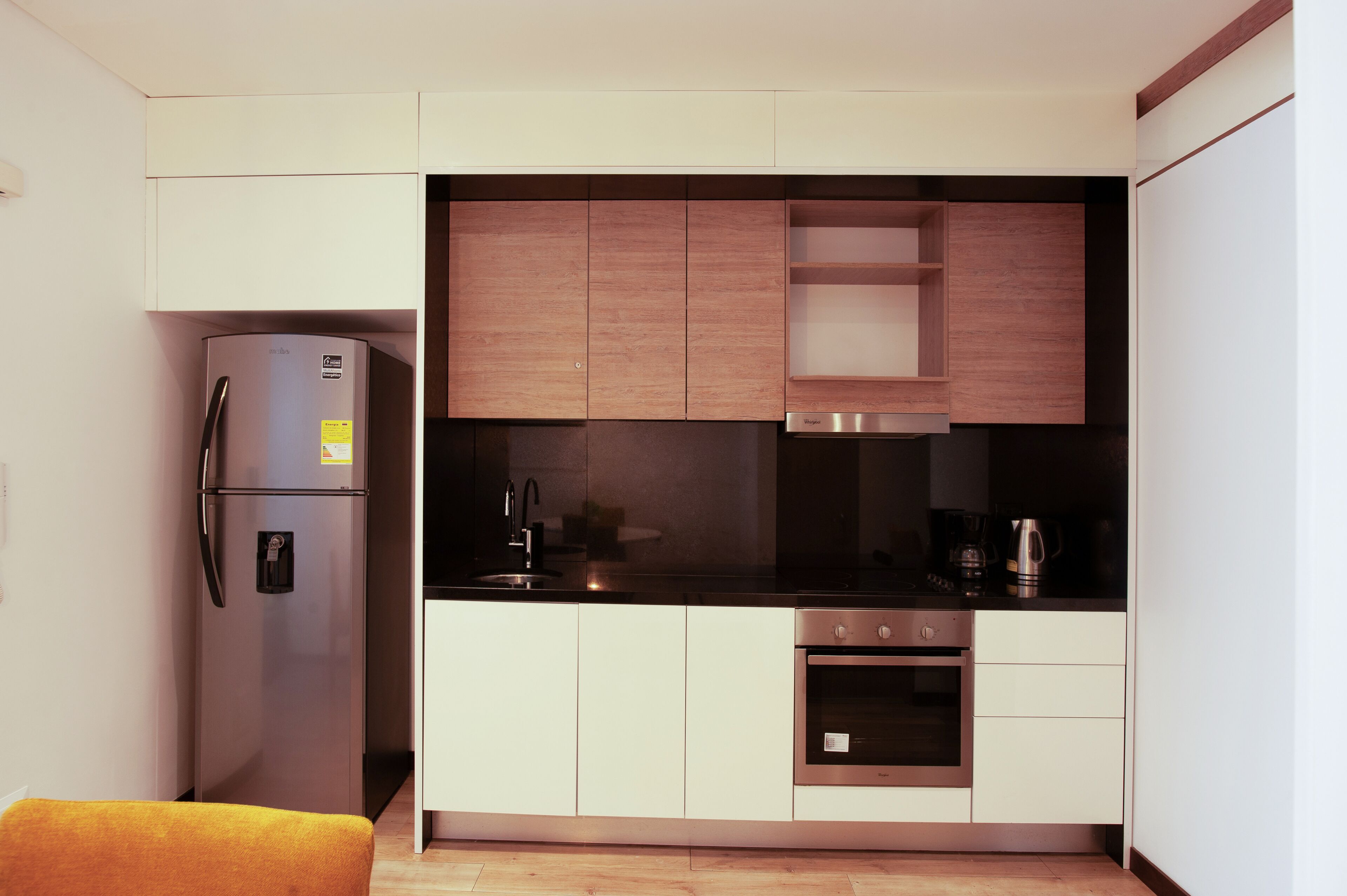 Una cocina compacta con refrigerador, horno y pileta integrados.