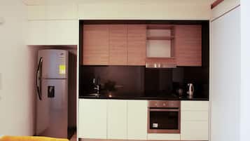 Una cocina compacta con refrigerador, horno y pileta integrados.