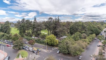 An aerial view of a city intersection surrounded by dense trees and a golf course.