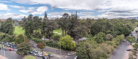 Vista aérea de una intersección urbana rodeada de árboles densos y un campo de golf.