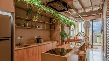 Una cocina moderna con armarios de madera, estufa integrada y plantas colgantes.