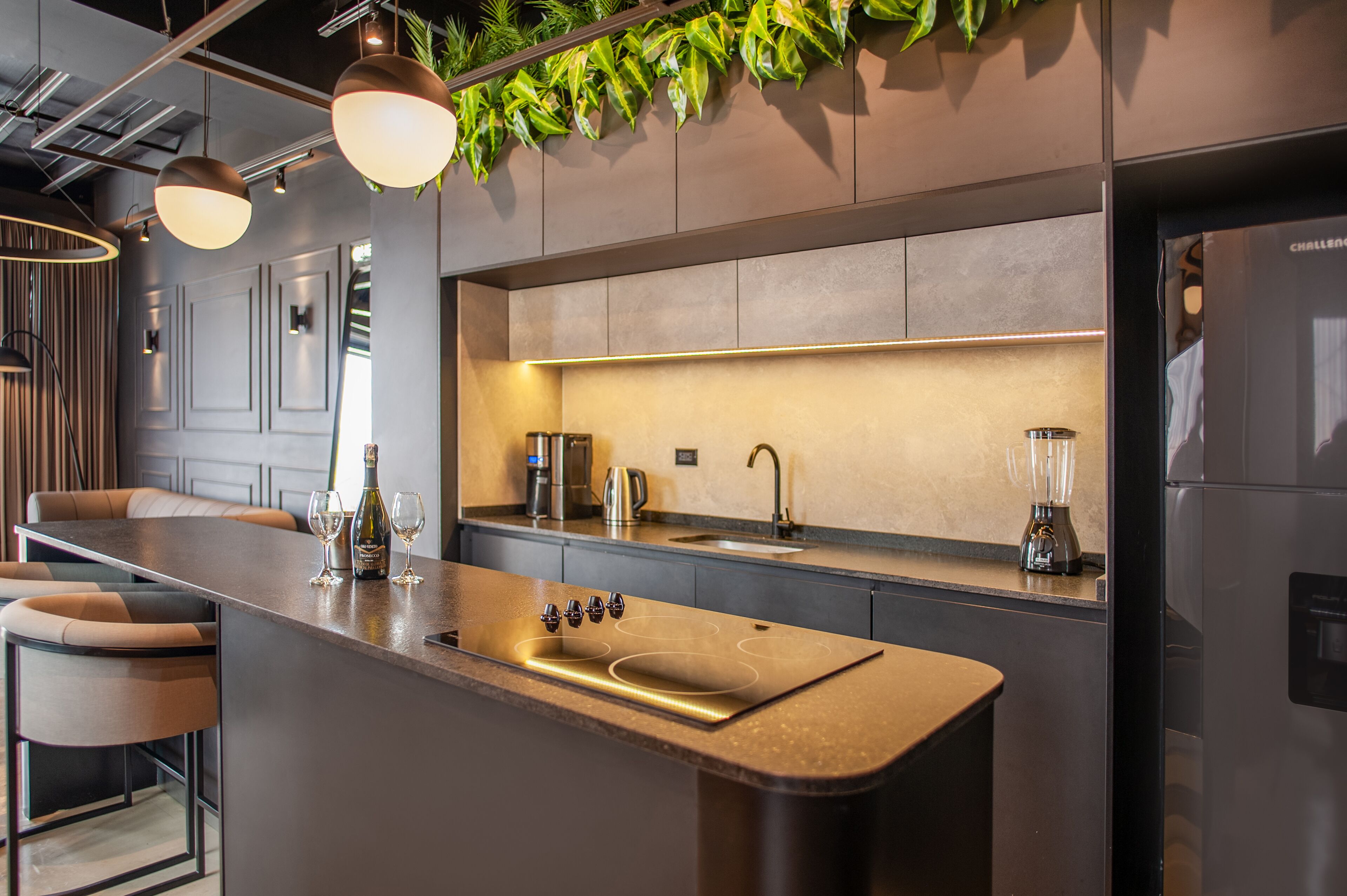 A modern kitchen with a central island, stainless steel appliances, and pendant lighting.