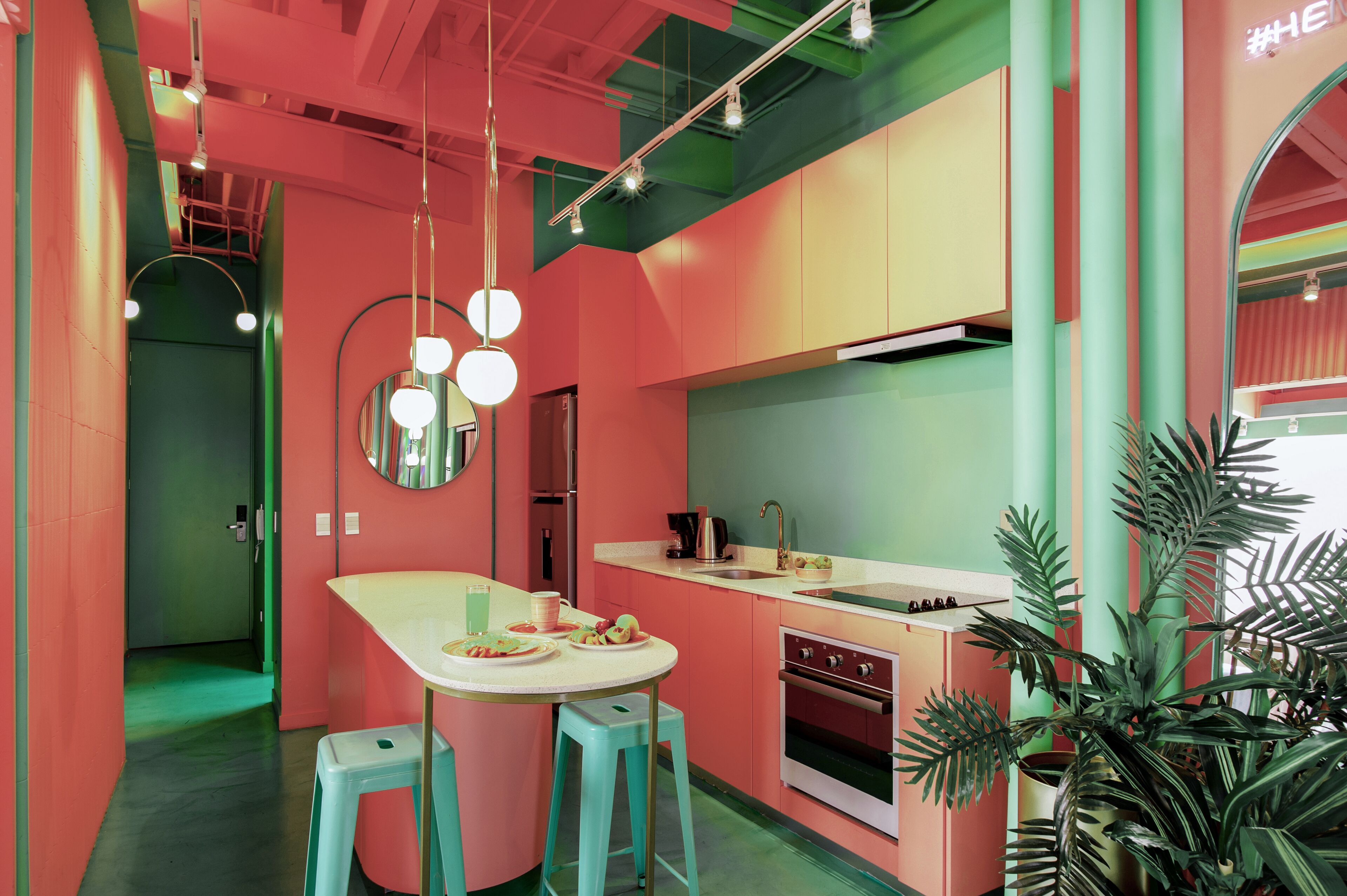 A vibrant kitchen with a central island, bar stools, a sink, and a stove.